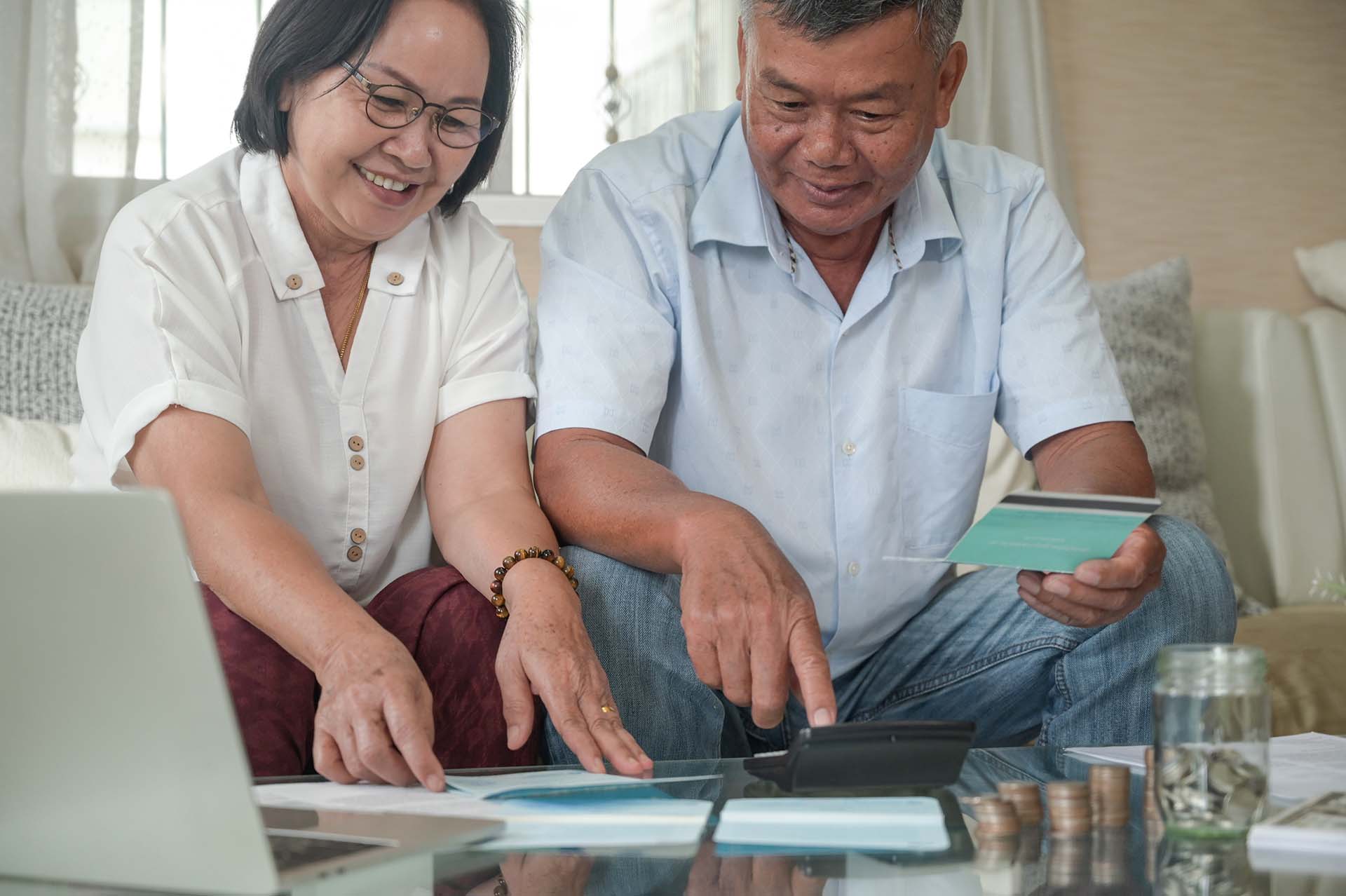 Retirement men and women check their savings with a happy expres