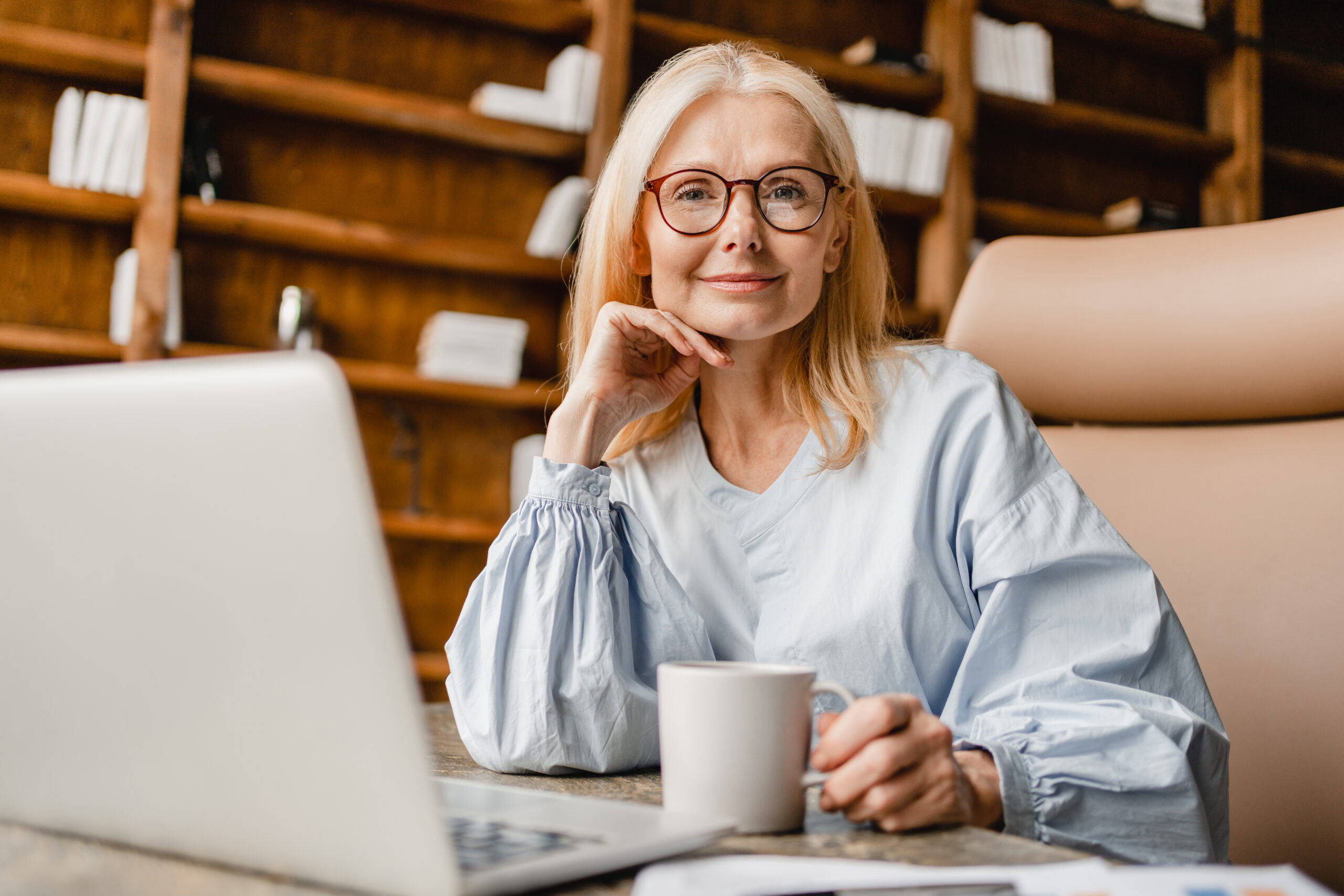 Freelancer working on distance on laptop, drinking coffee, watching webinars, e-learning online